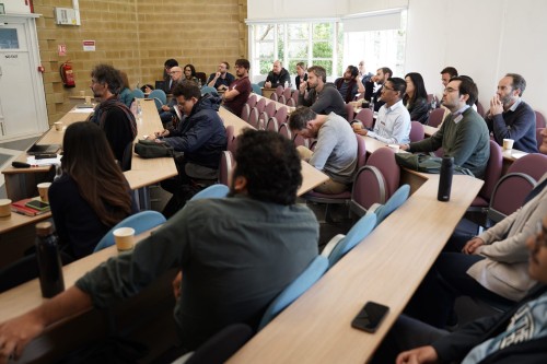 An audience of academics watch a research presentation